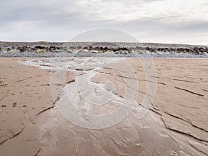 Seawater draining out of the sand on beach. North Devon, UK.