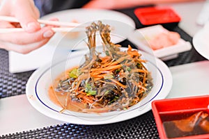 Seaweed Salad with Carrot on white plate in chinese buffet restaurant