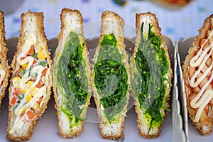 Seaweed salad sandwich for sell at street food market in Thailand . Tasty green seaweed salad sandwich close up