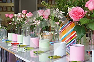 Secateurs, boxes and flowers in vases are being prepared for a master class on assembling bouquets. No people