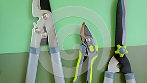 Secateurs, loppers and hedge trimmers on a green combined background