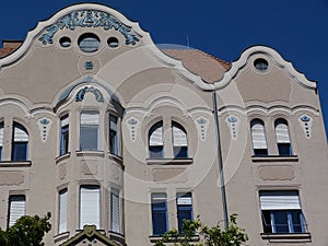 Secessionist style facade detail with balcony and white windows in Szeged, Hungary