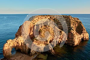 Secluded limestone island and beach Praia JoÃ£o de Arens in Algarve, Portugal