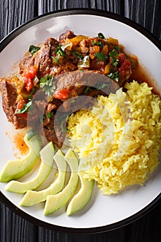 Seco de chivoï¿½is goat stew with yellow rice and avocado close-up