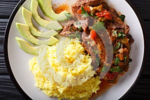 Seco de chivoÃ¯Â¿Â½is goat stew with yellow rice and avocado close-up photo
