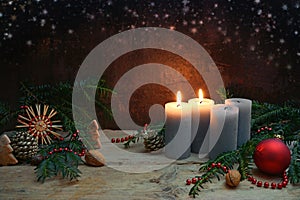 Second Advent, two of four candles are lighted, red bauble, straw star, fir branches and Christmas decoration on rustic wooden photo