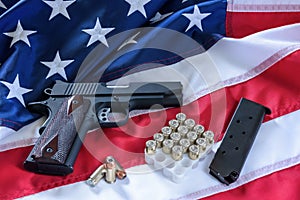 The second amendment and gun control in the US, concept. A handgun, a magazine, bullets, and the american constitution on the USA