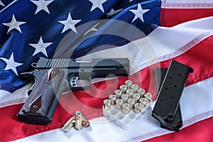 The second amendment and gun control in the US, concept. A handgun, magazines, bullets, and the american constitution on the USA f