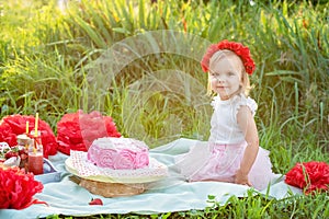 second birthday of little girl. Two years old girl sitting near celebration decorations and eating her birthday cake. Cake Smash