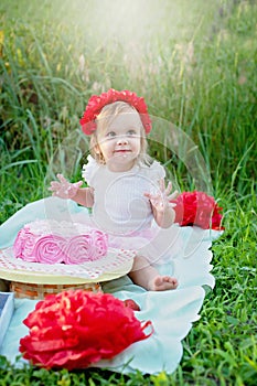 second birthday of little girl. Two years old girl sitting near celebration decorations and eating her birthday cake. Cake Smash