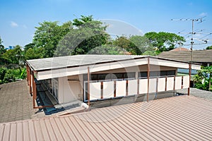 second floor house building with pattern tiles roof. brown metal sheet roofs