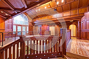 Second floor landing accented with wood paneled walls and ceiling.