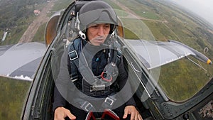 Second pilot man dancing in aircraft. Gray combat fighter plane flying quickly and low over ground against the cloudy overcast