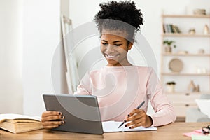 Secondary School Student Girl Studying Using Digital Tablet At Home