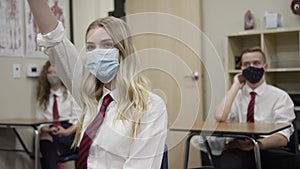 Secondary school students in UK wear masks in class as teen girl raises hand