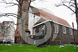 Secret garden of the beghine of amsterdam. statue in the middle of the green in the reserved and silent neighborhood inhabited by