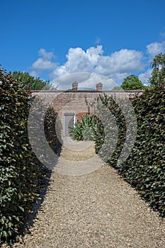 Secret garden. Gravel path leading to a walled garden gate.