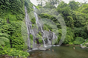 Secret jungle waterfall cascade in tropical rainforest with rock