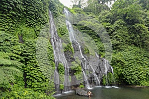 Secret jungle waterfall cascade in tropical rainforest with rock