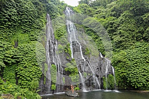 Secret jungle waterfall cascade in tropical rainforest with rock