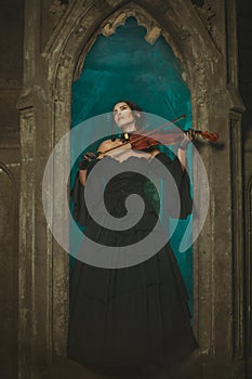Secret medieval girl playing the violin at night.
