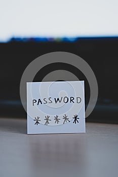 Secret password written on paper note on  keyboard with wooden desk on background. Login access, encryption and cyber security con