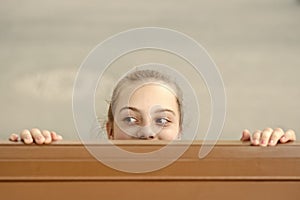 Secret place for hiding. Cute small child hiding under the table. Little girl hiding and peeping out with curiosity