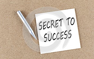 SECRET TO SUCCESS text on a sticky note on cork board with pencil