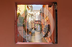 Secret window in the wall to the hidden part of the city in Bologna, Italy. Canal of Reno in Piella street photo