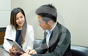 A secretary and boss is discussing about their project in meeting room