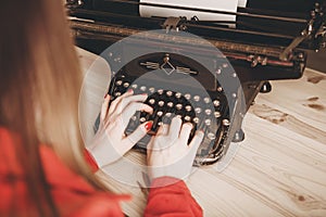 Secretary at old typewriter with telephone. Young woman using ty