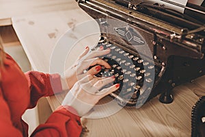 Secretary at old typewriter with telephone. Young woman using ty