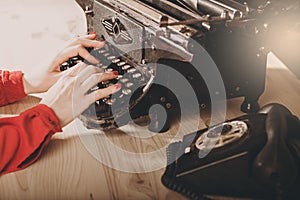 Secretary at old typewriter with telephone. Young woman using ty