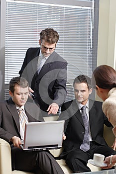 Secretary serving cup of coffee to young business men in the office