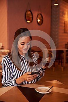 Secretive millenial in restaurant with phone