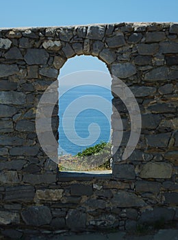 Section of ancient wall around the Doria Castle in Portovenere with an arched window hole