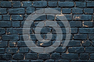 A section of a blue brick wall with a single yellow light on top