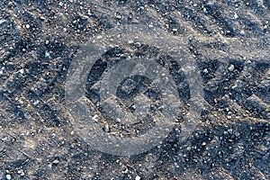 A section of a dirt road with a car tire tread print. Texture.