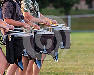 A section of a marching band drum line rehearsing
