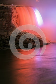 A section of Niagara Falls and river iluminated in a dazzling re