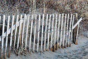 Section of old rusting wood fencing at sandy beach