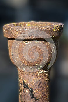 A section of an old sewer pipe. Vertical shot. Blurred dark background