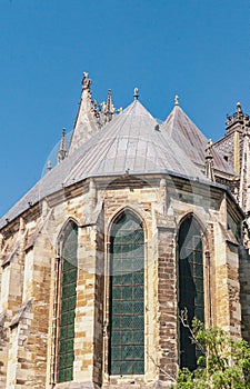 Section of smaller towers, three tall panals of stained glass, back side of, cathedral of, our lady of Rhems, against a blue sky