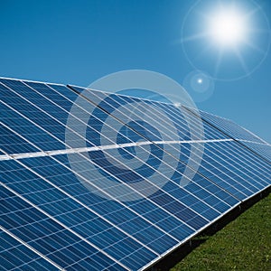 Section of solar power plant with sun and blue sky, vertical image