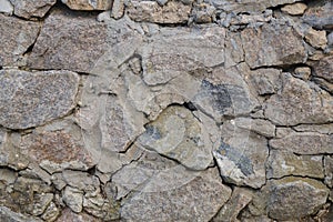 A section of a stone wall made of granite stone. Close-up. Horizontal