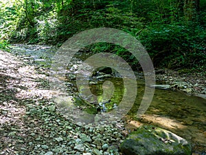 Sections of a mountain river that dry up in hot summer, walking along the canyon on a sunny day, communicating with nature,wild pl