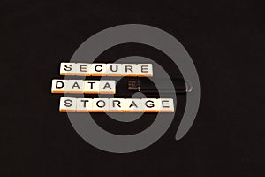Secure data storage spelled out with tiles on a black background with a USB drive to the right