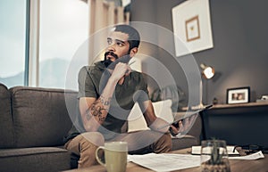 A secure financial future is closer than you think. a young man using a digital tablet while going through paperwork at