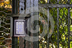 Secure password on keyboard for opening door. Metal code lock. Background of trees in the park