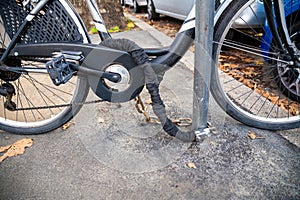 Securely Locked Bicycle to a Metal Post on Sidewalk